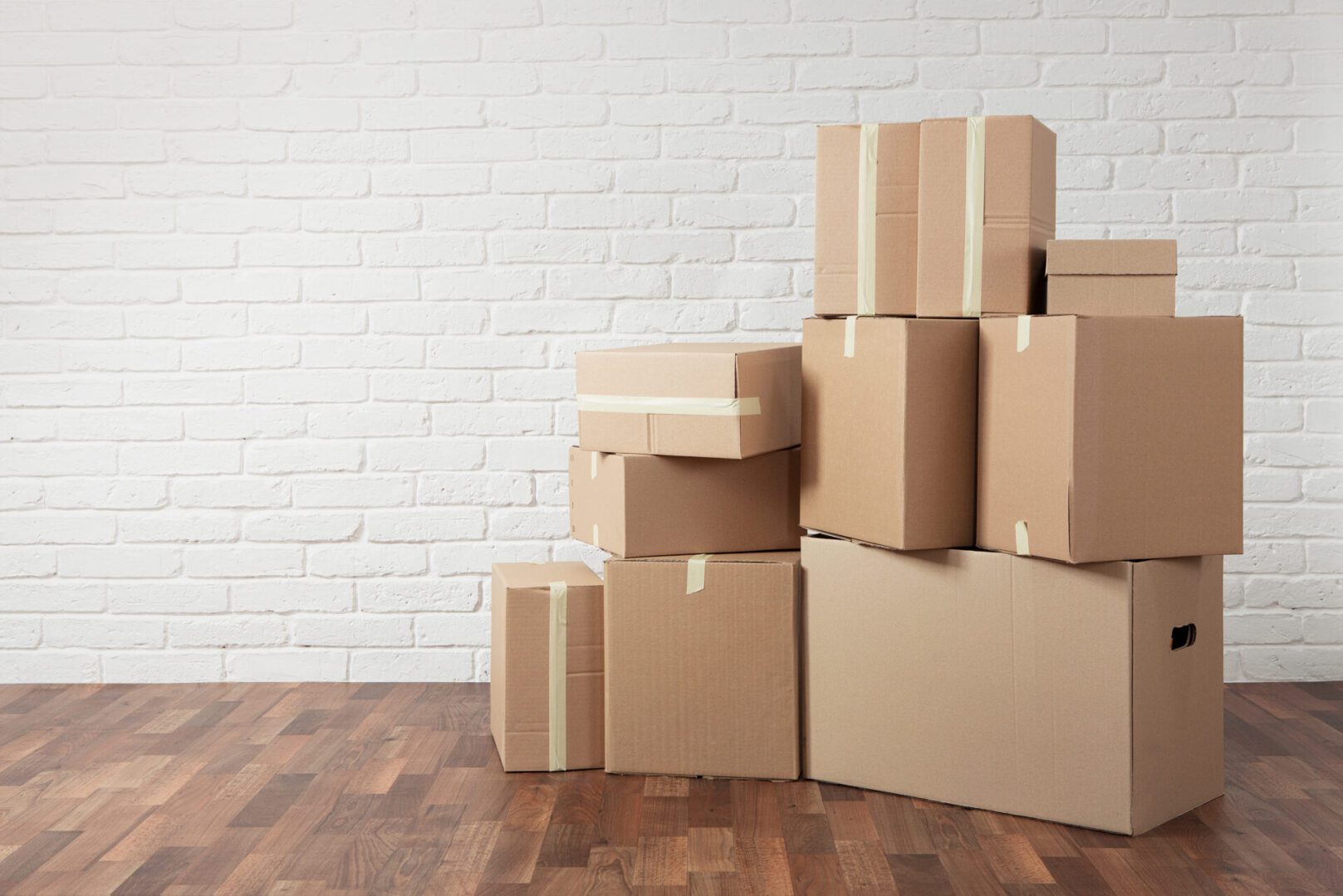 Moving,In.,Stack,Of,Cardboard,Boxes,In,The,Empty,Room